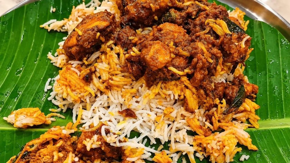 Authentic Bagara rice with chicken curry on banana leaf